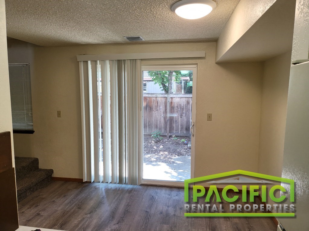 a living room with a sliding glass door to a backyard