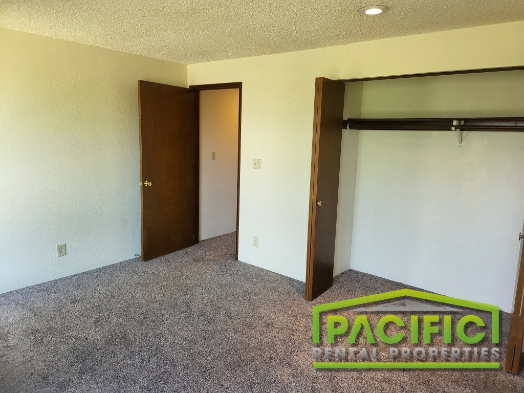 a bedroom with a closet and a carpeted floor