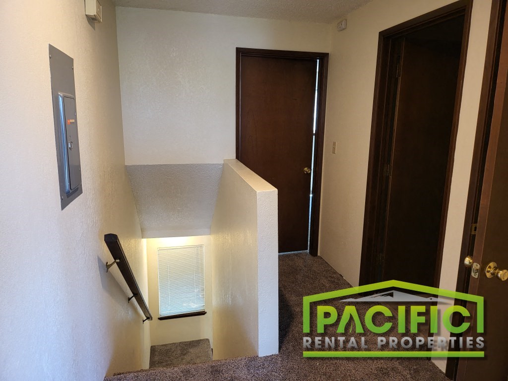 a stairwell in a home with a wall air conditioner and a door