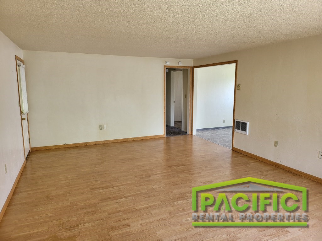 the living room and dining room of an empty house with wood floors