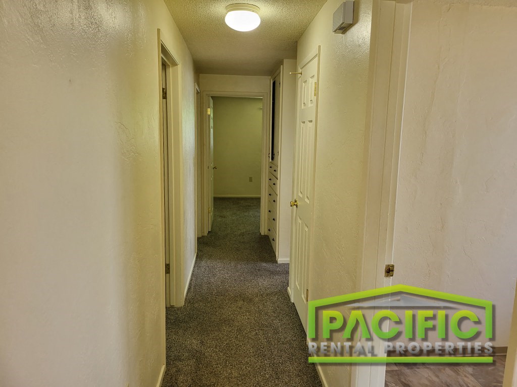 a long hallway with a carpeted floor and white walls