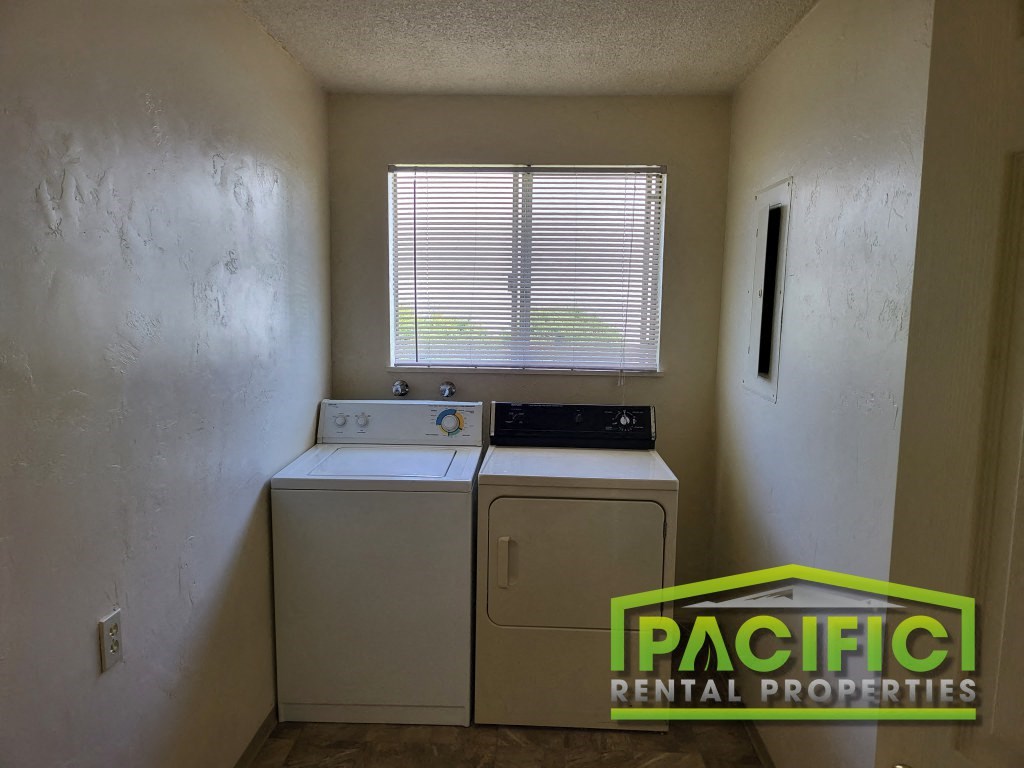a laundry room with a washing machine and a window