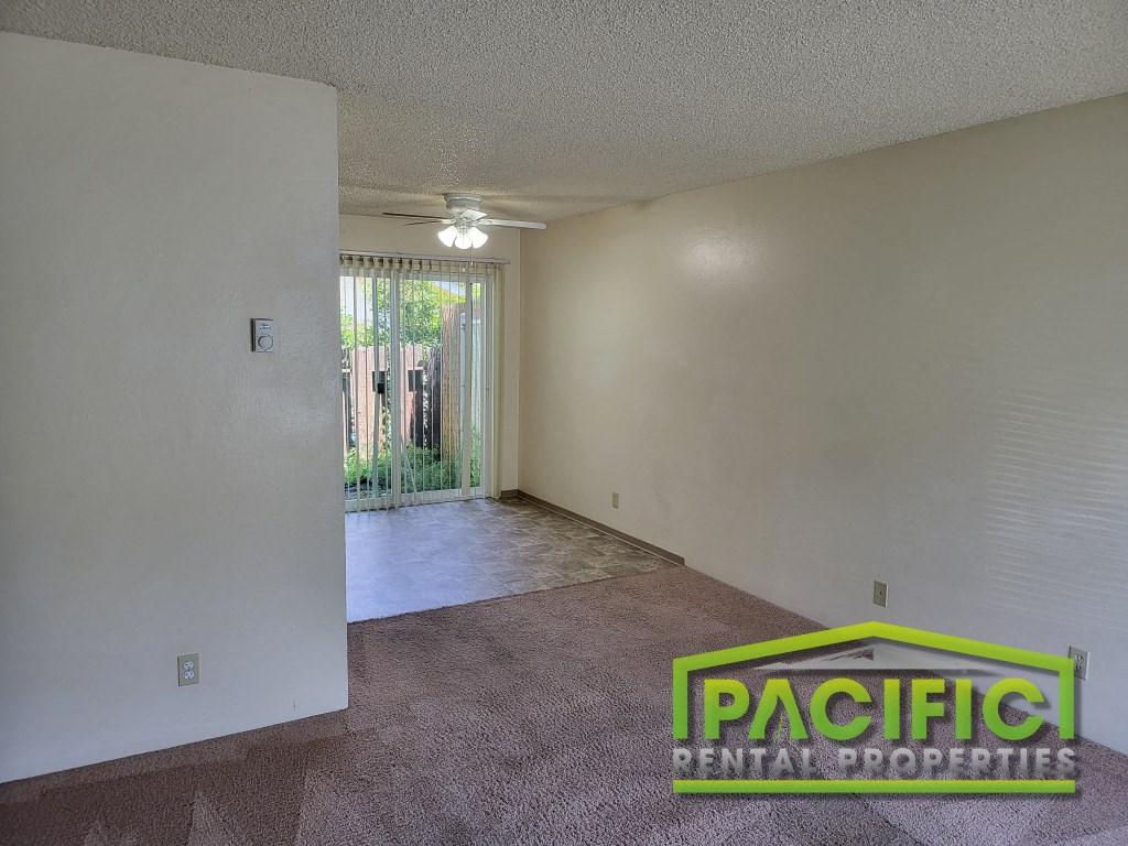 the living room and dining room of an empty apartment
