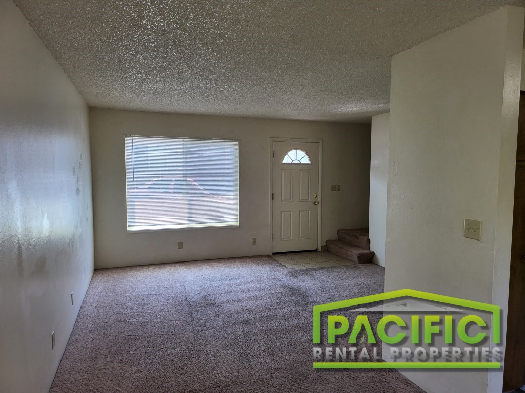 the living room of an empty house with a window