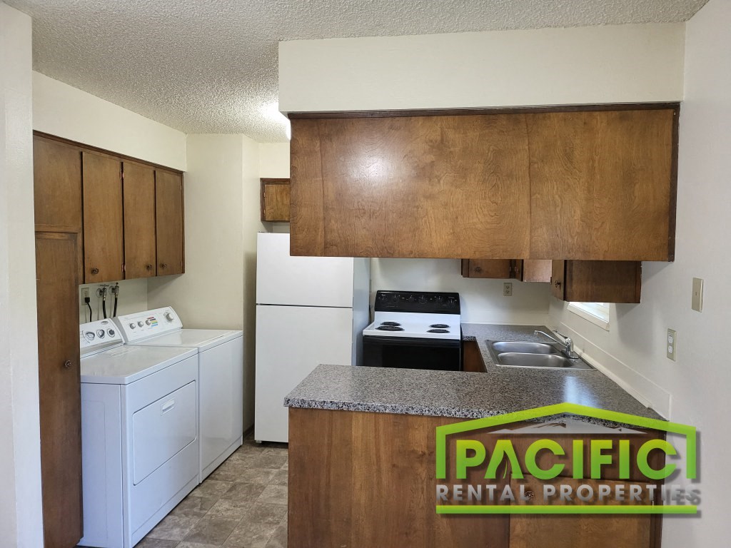 a kitchen with white appliances and wooden cabinets