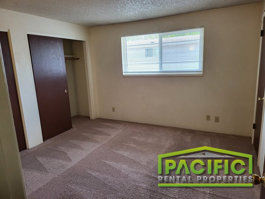 an empty room with a carpeted floor and a window