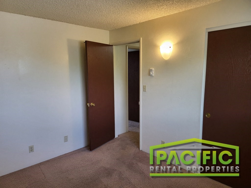 a bedroom with two doors and a closet and a door to the bathroom