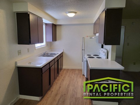 an empty kitchen with white counter tops and black cabinets