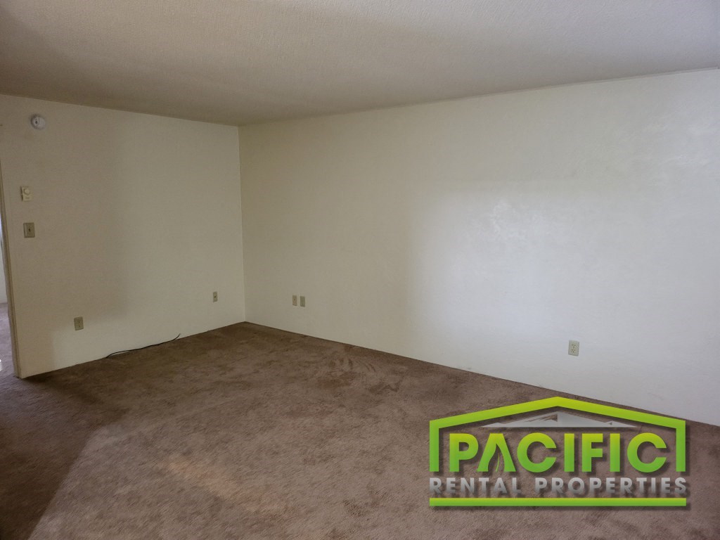 the living room of an empty house with carpet and white walls