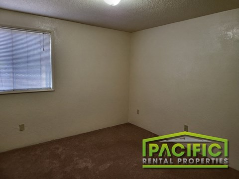 the interior of an empty room with a window and the pacific rental properties logo
