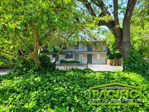 a house with a street sign in front of a tree