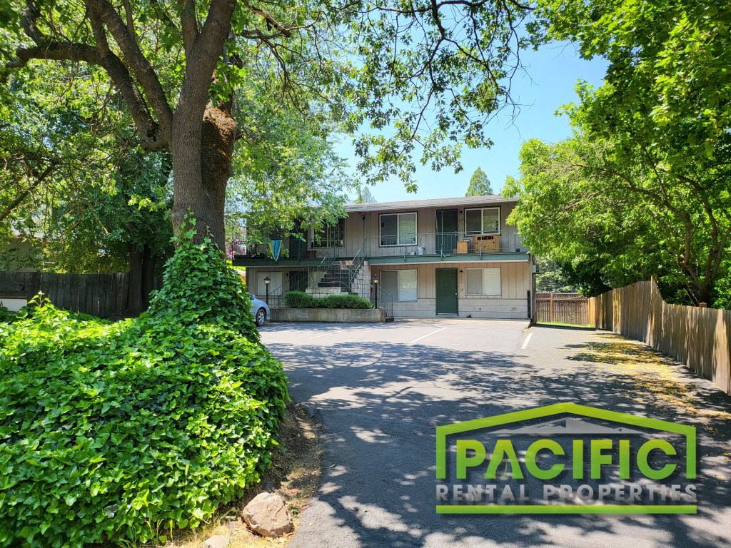 a house with a driveway and a tree in front of it