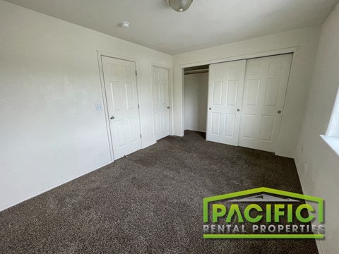 the living room of a manufactured home with white walls and carpet