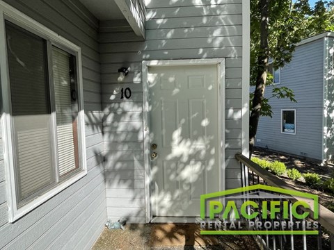 a front door of a gray house with a porch
