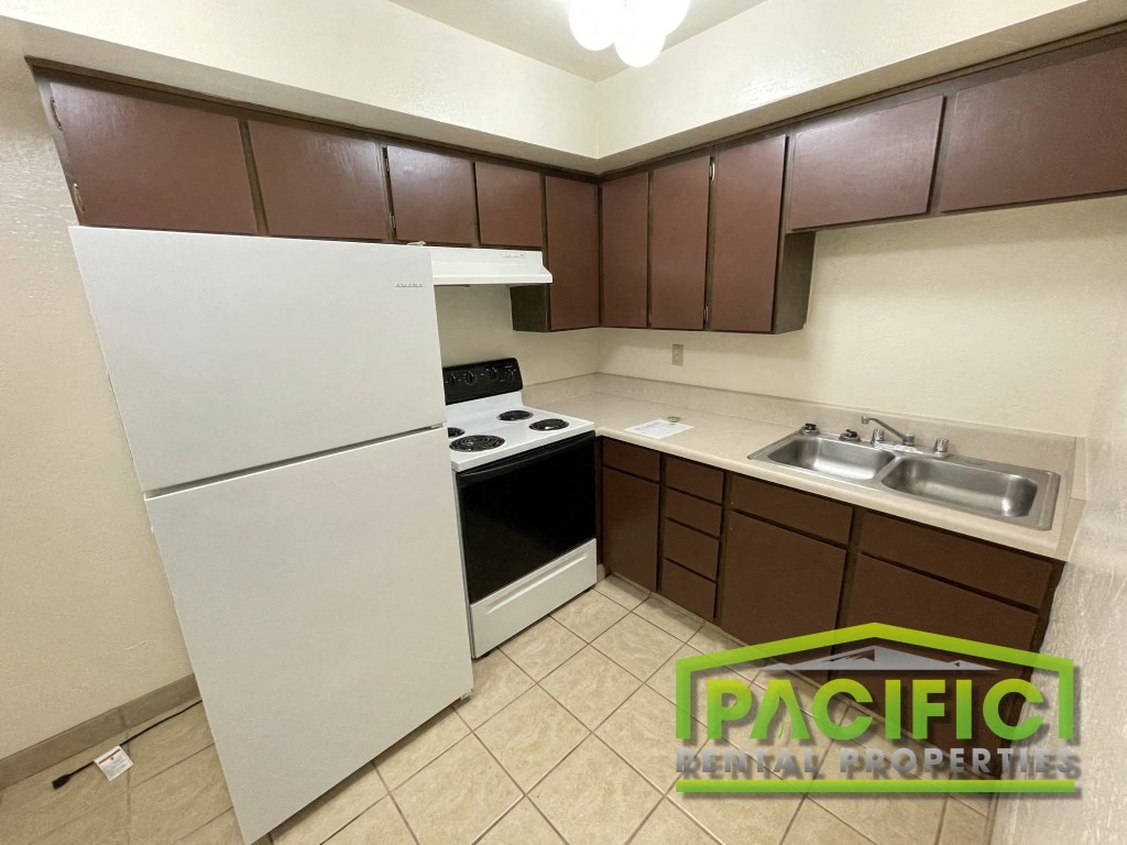 a kitchen with white appliances and brown cabinets