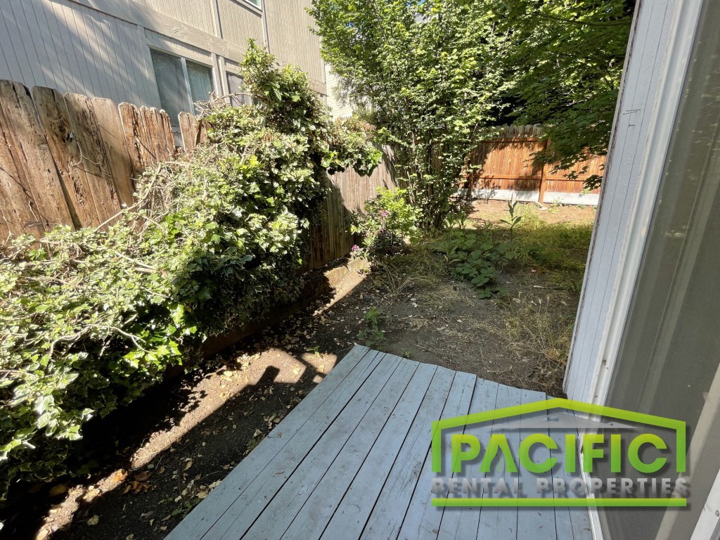 a backyard with a wooden deck and a fence