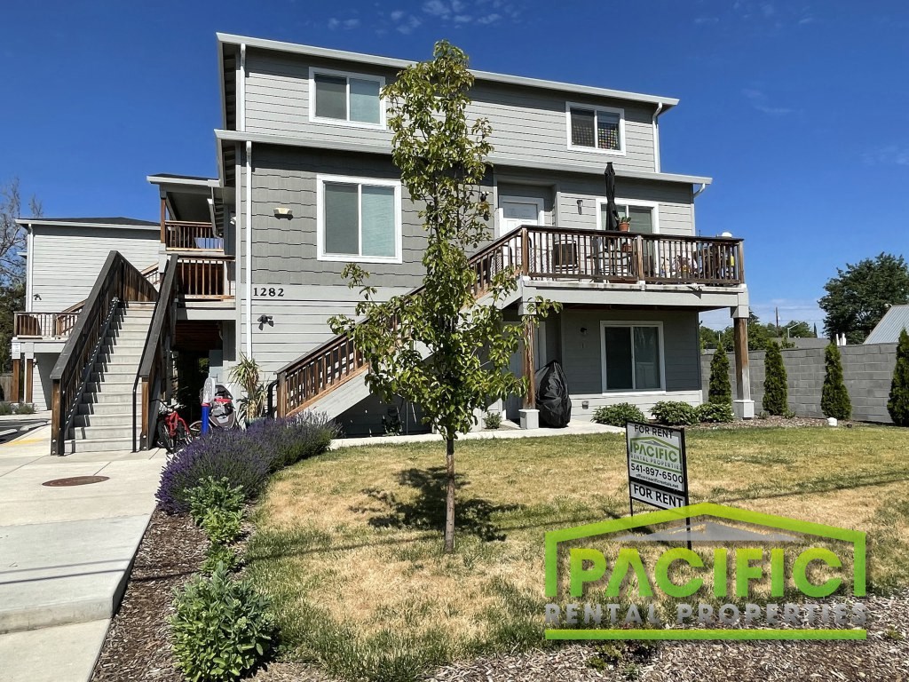 a house with stairs and a yard in front of it