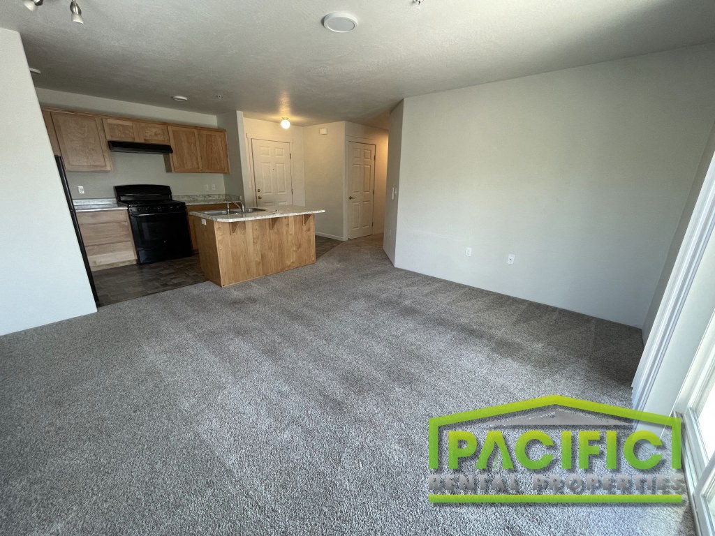 an empty living room with a kitchen in it