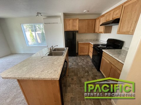 an empty kitchen with wood cabinets and a sink