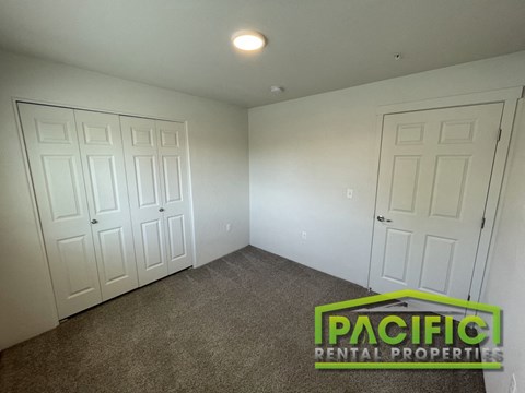 a bedroom with two closets and a carpeted floor