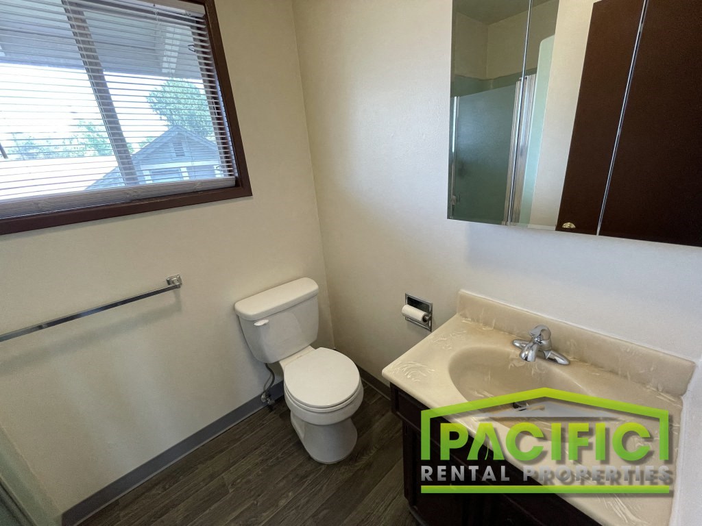 a bathroom with a toilet and a sink and a window