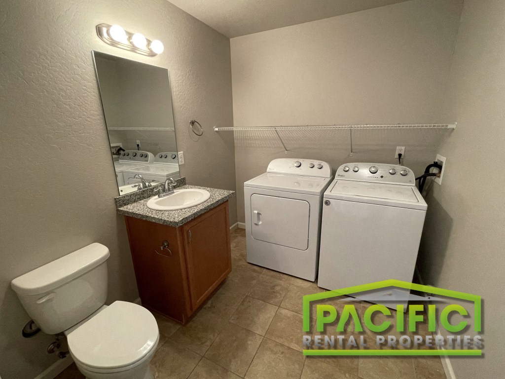 a small bathroom with a washer and dryer and a toilet and a sink