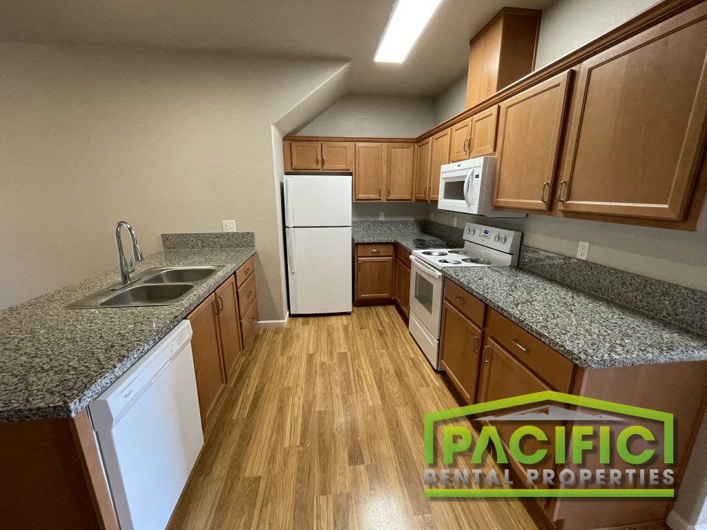 a kitchen with granite counter tops and wooden flooring