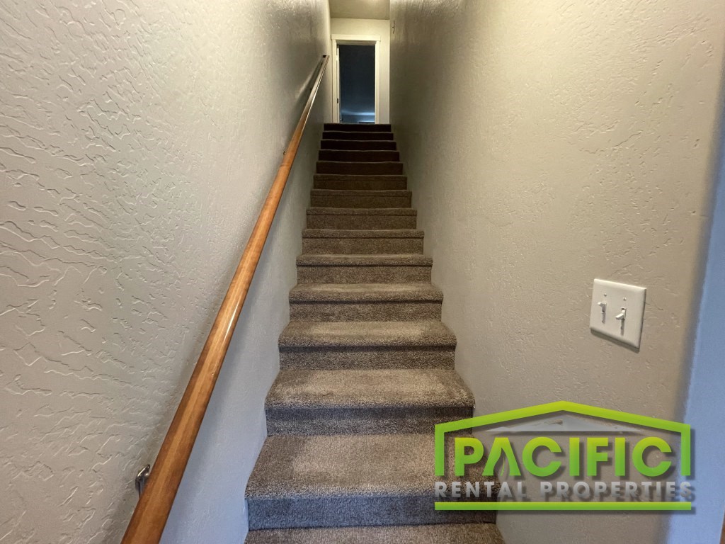 a set of stairs with a green pacific rental properties sign on the bottom of