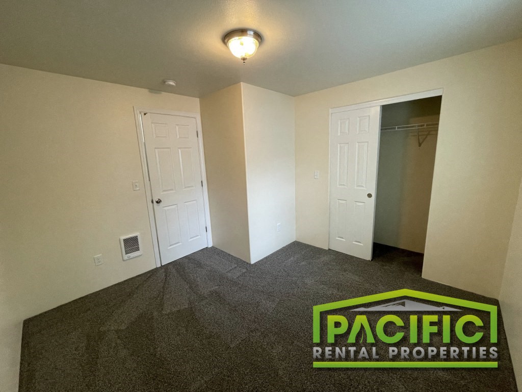 an empty room with a carpeted floor and a closet