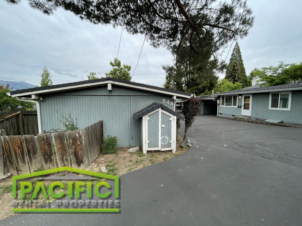 a street with a blue house and a blue shed