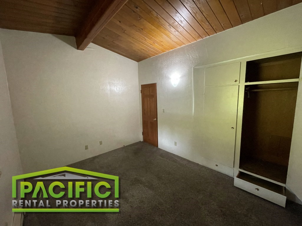 the living room of a house with white walls and a door