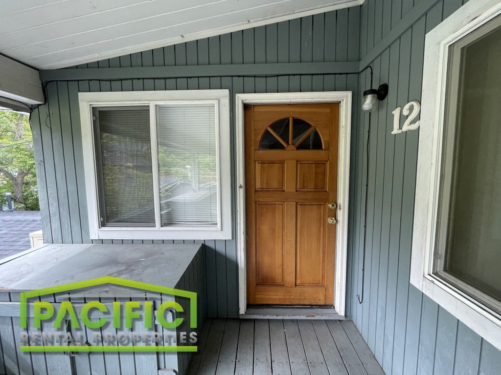 a front porch of a house with a wooden door