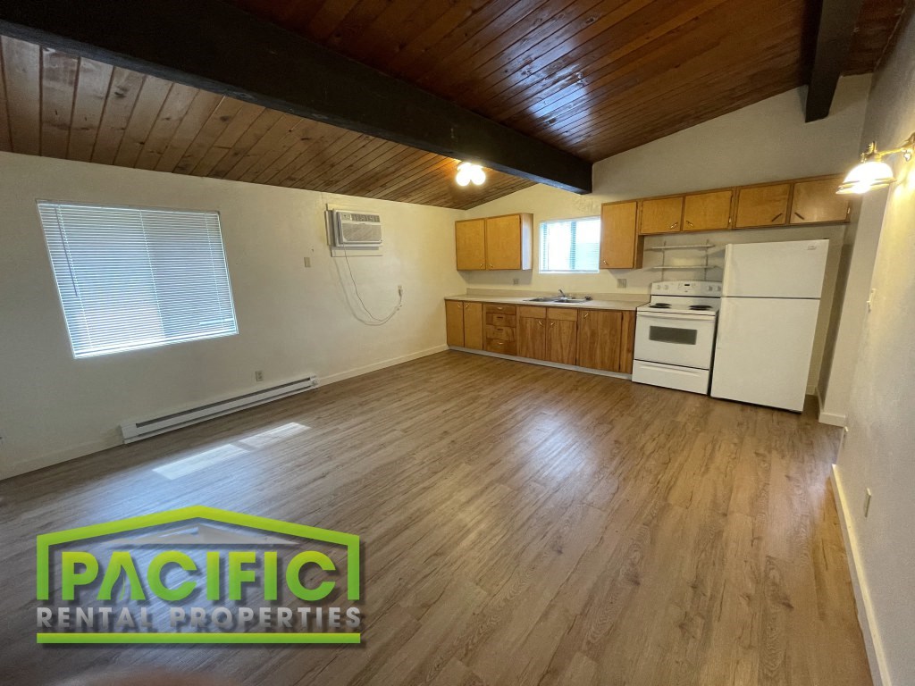 the kitchen and living room of a house with wood floors