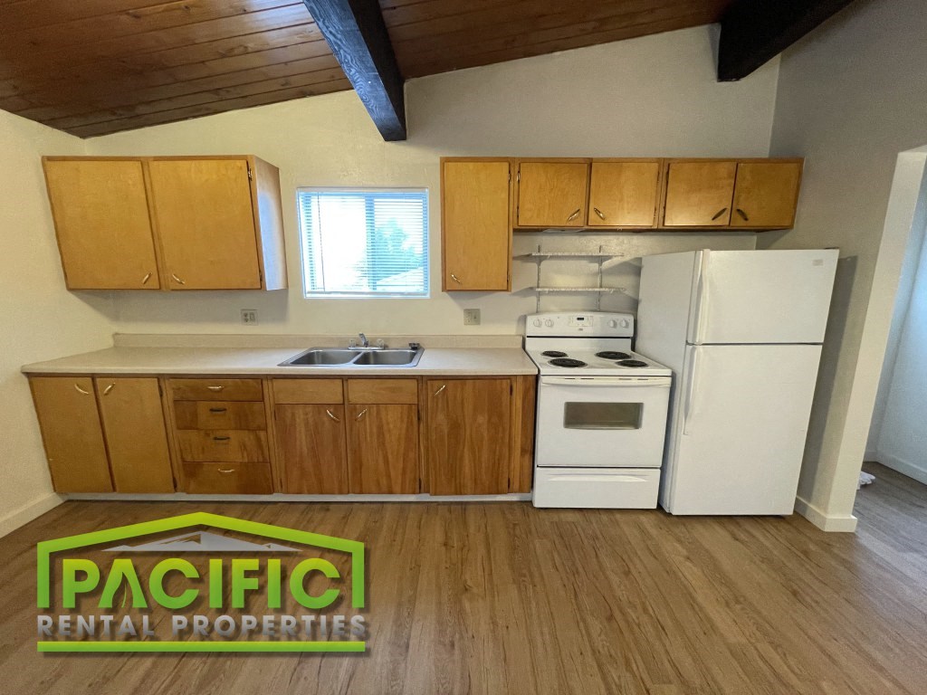 a kitchen with a stove refrigerator and a sink