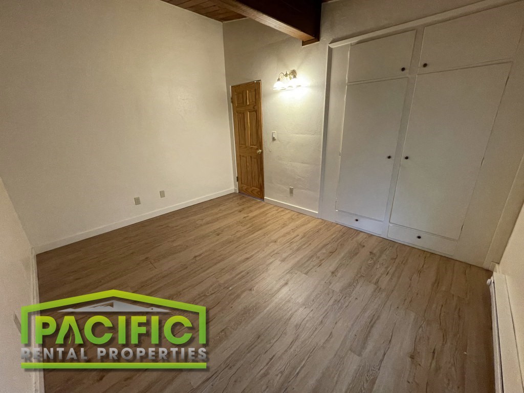 the living room of a house with white walls and wood floors