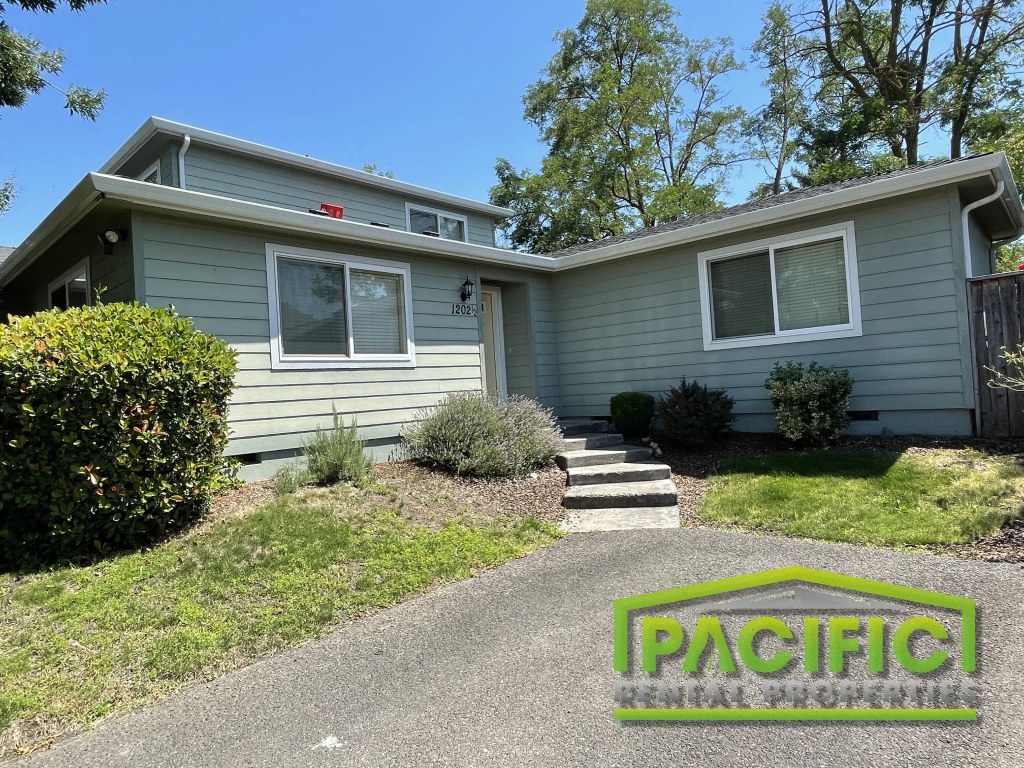 a blue house with a driveway and stairs