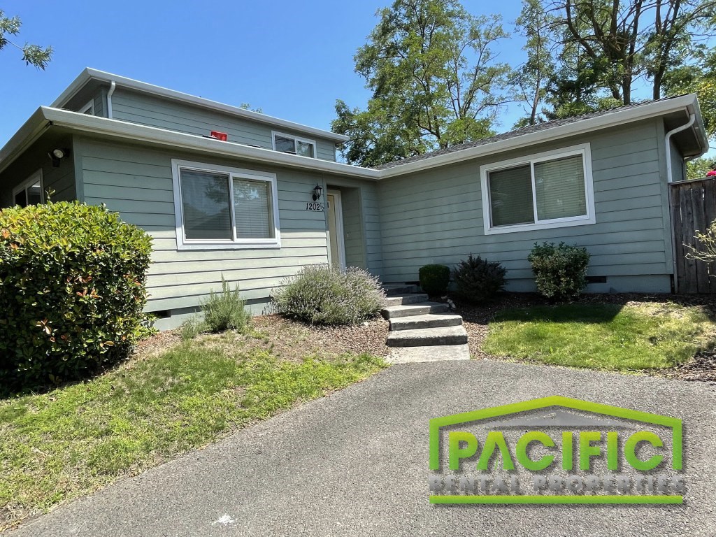 a blue house with a driveway and stairs