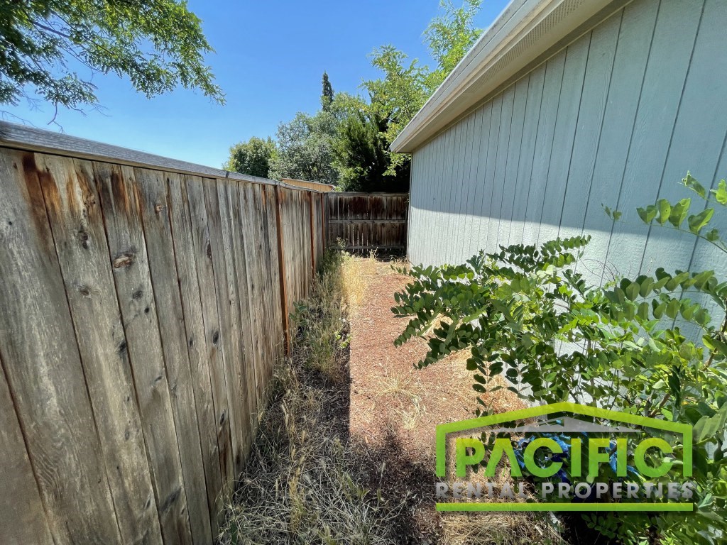 a backyard with a wooden fence and a garden