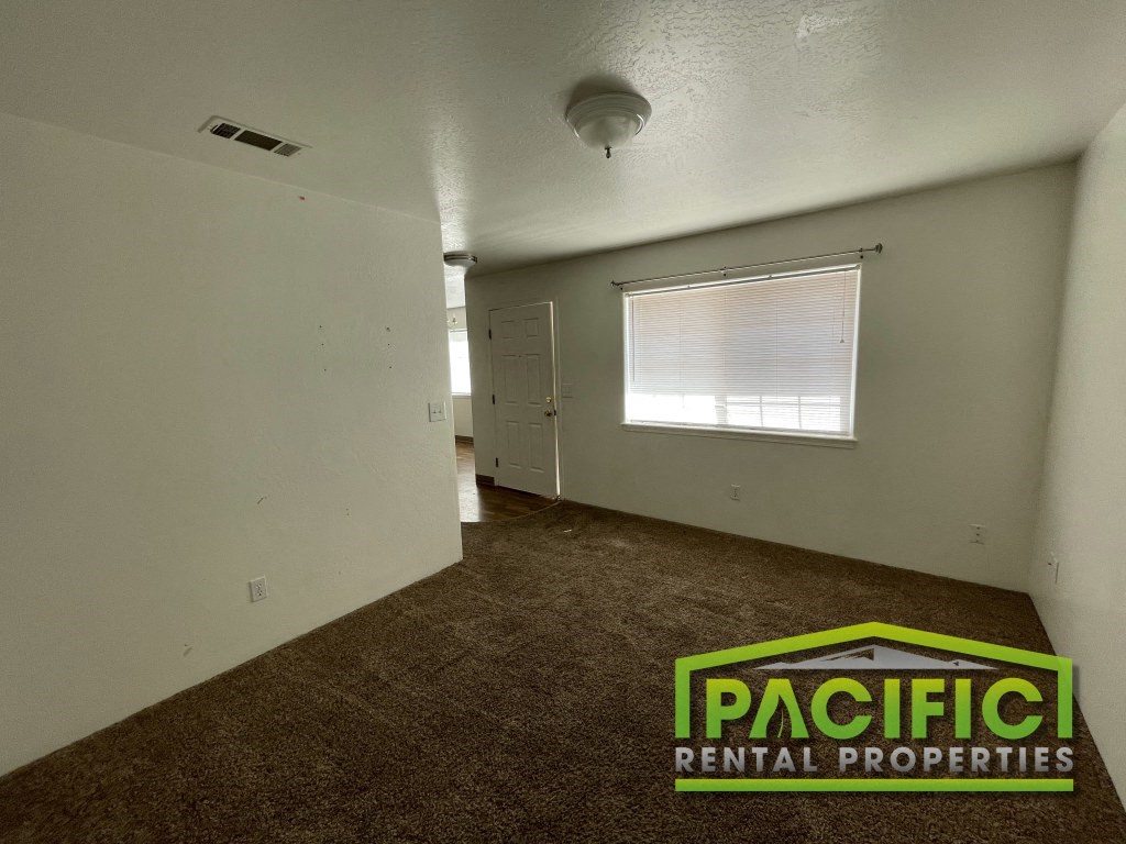the interior of an empty room with a door and a window