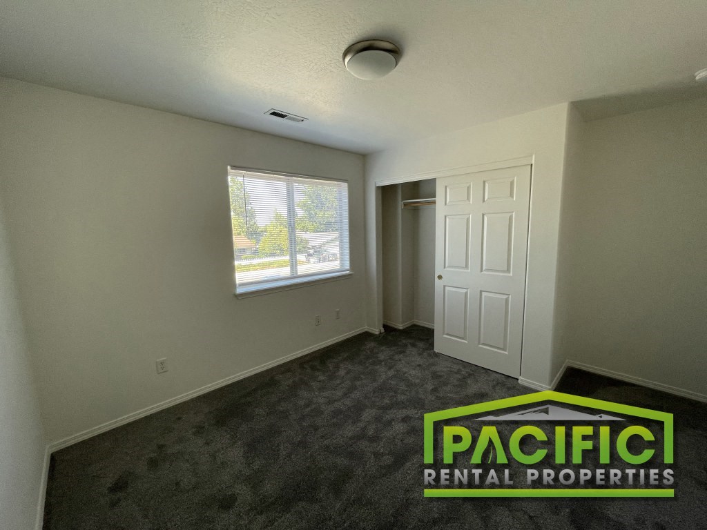 an empty living room with carpet and a window