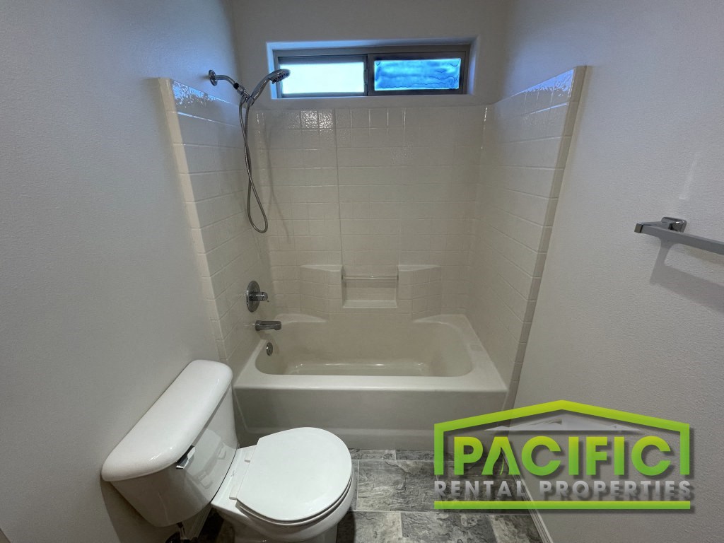 a small bathroom with a toilet and a bath tub