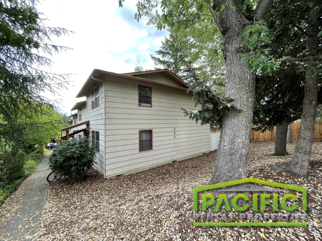 a white house with a tree in front of it