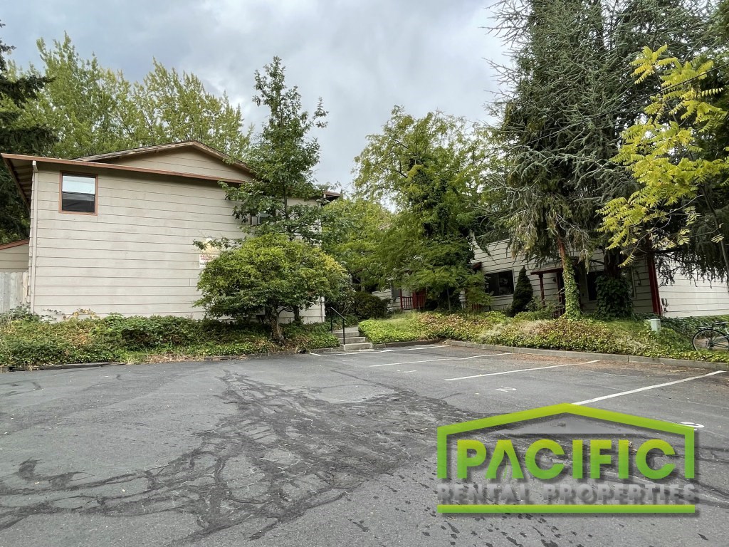 an empty parking lot in front of a house