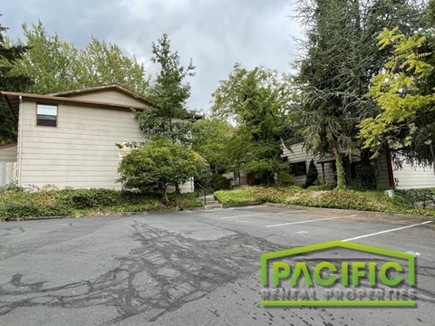 an empty parking lot in front of a house
