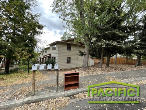 a house with a wood stove in front of a driveway