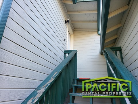 a staircase with a green bench next to a white building