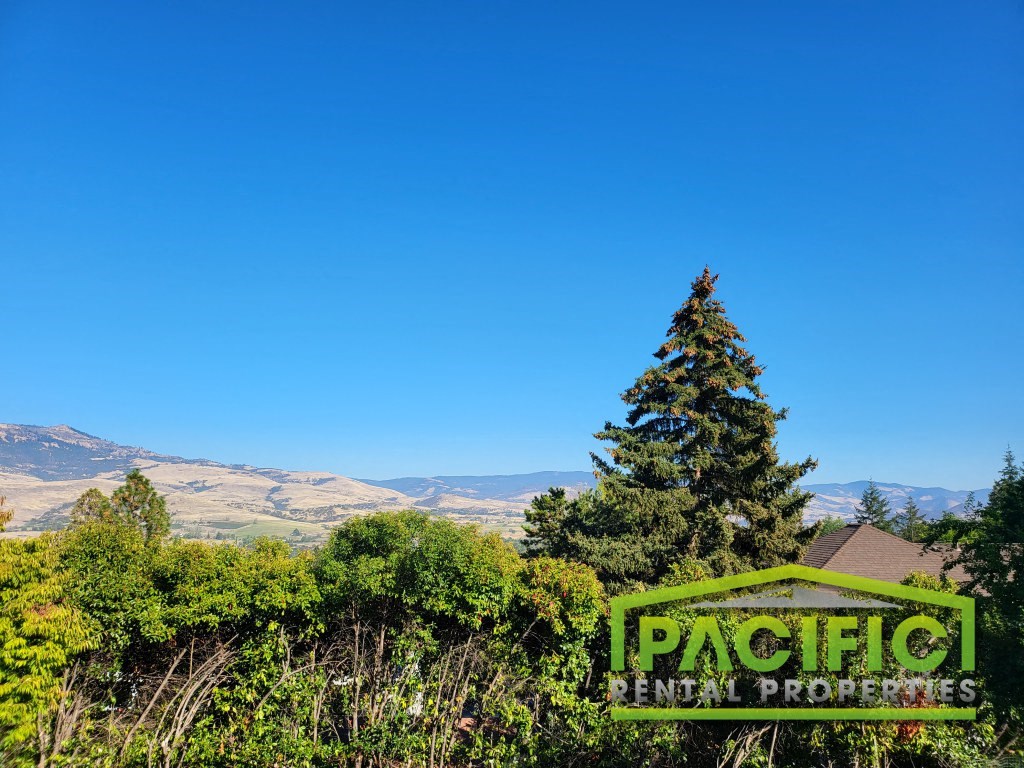 a sign for pacific land properties with mountains in the background