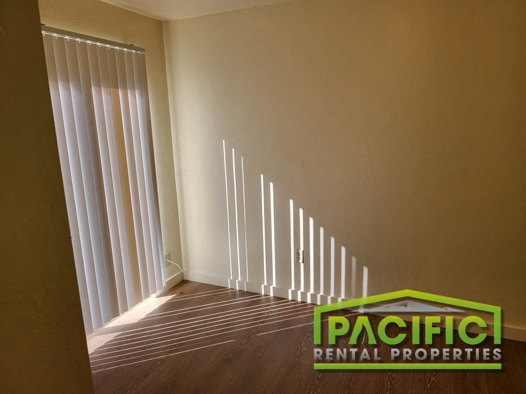 the interior of a room with vertical blinds on the window