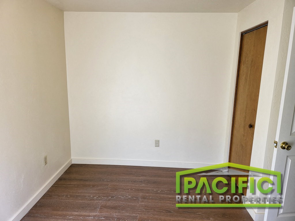 an empty room with white walls and a wooden floor
