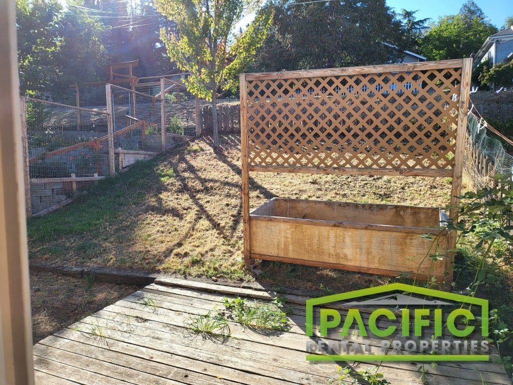 a backyard garden with a wooden bench and a wooden deck